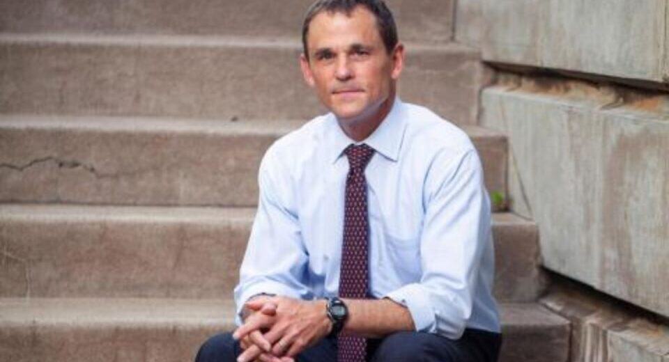 UVA President Jim Ryan seated on campus steps