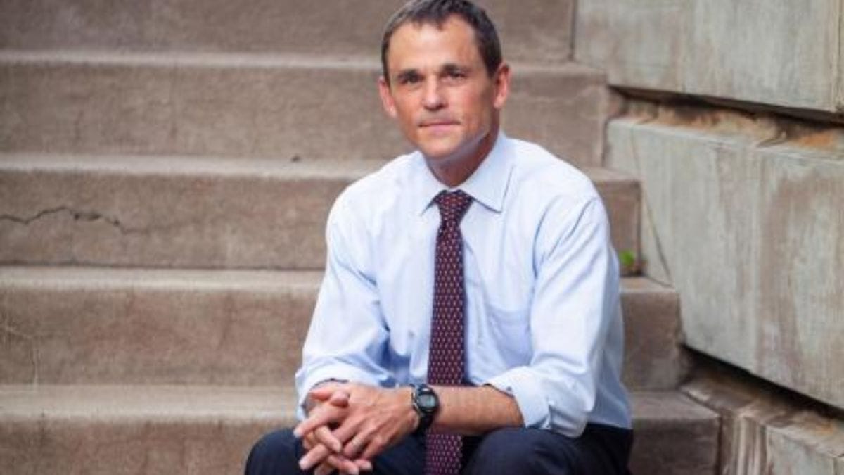 UVA President Jim Ryan seated on campus steps