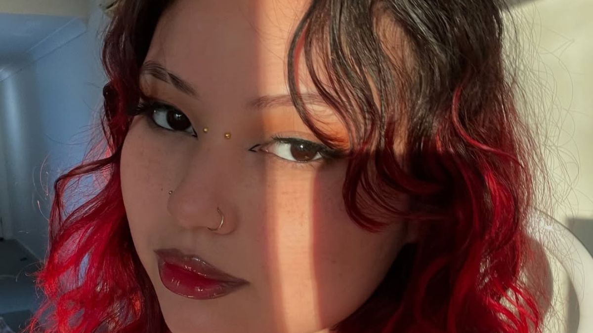 Ruby Jade with red curls gazes softly through filtered light