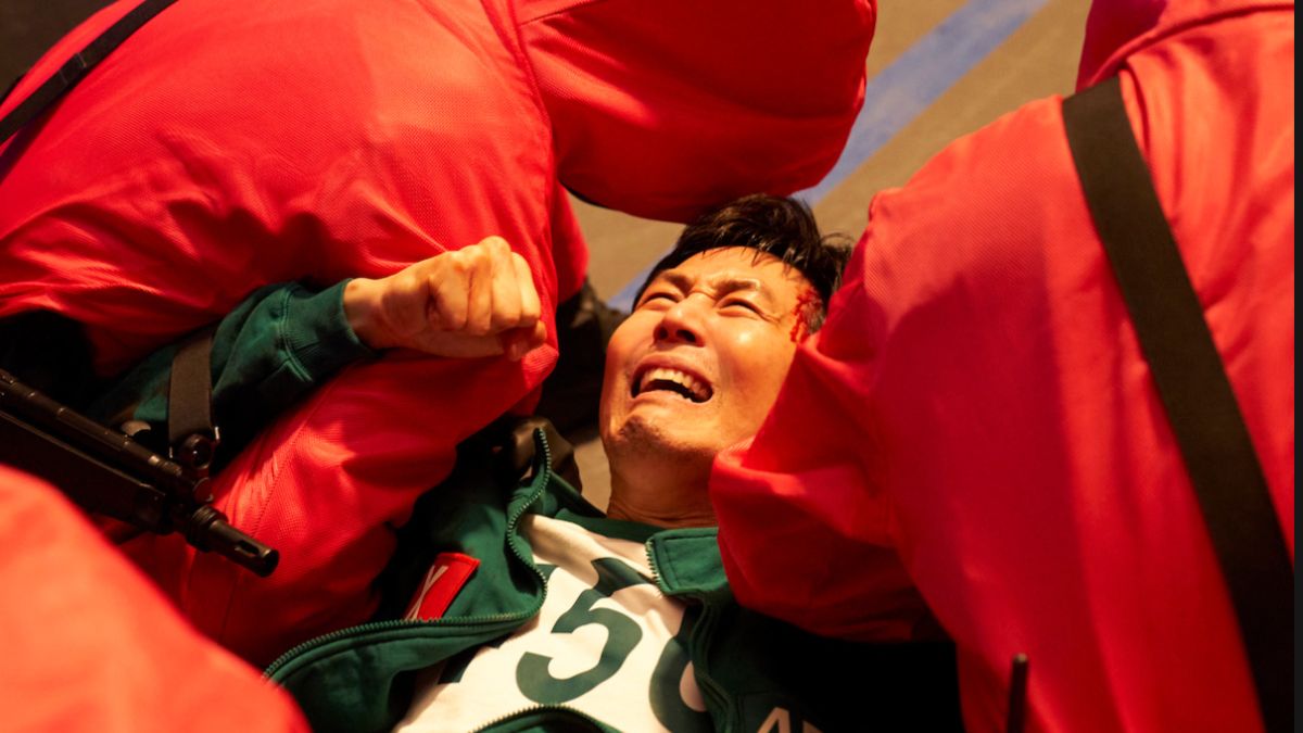 Gi-hun cries in pain while being restrained by guards in Squid Game Season 3
