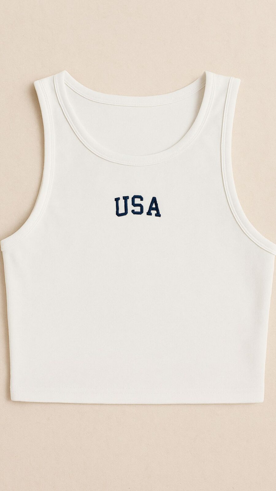 White minimalist crop tank top with “USA” text embroidered in navy