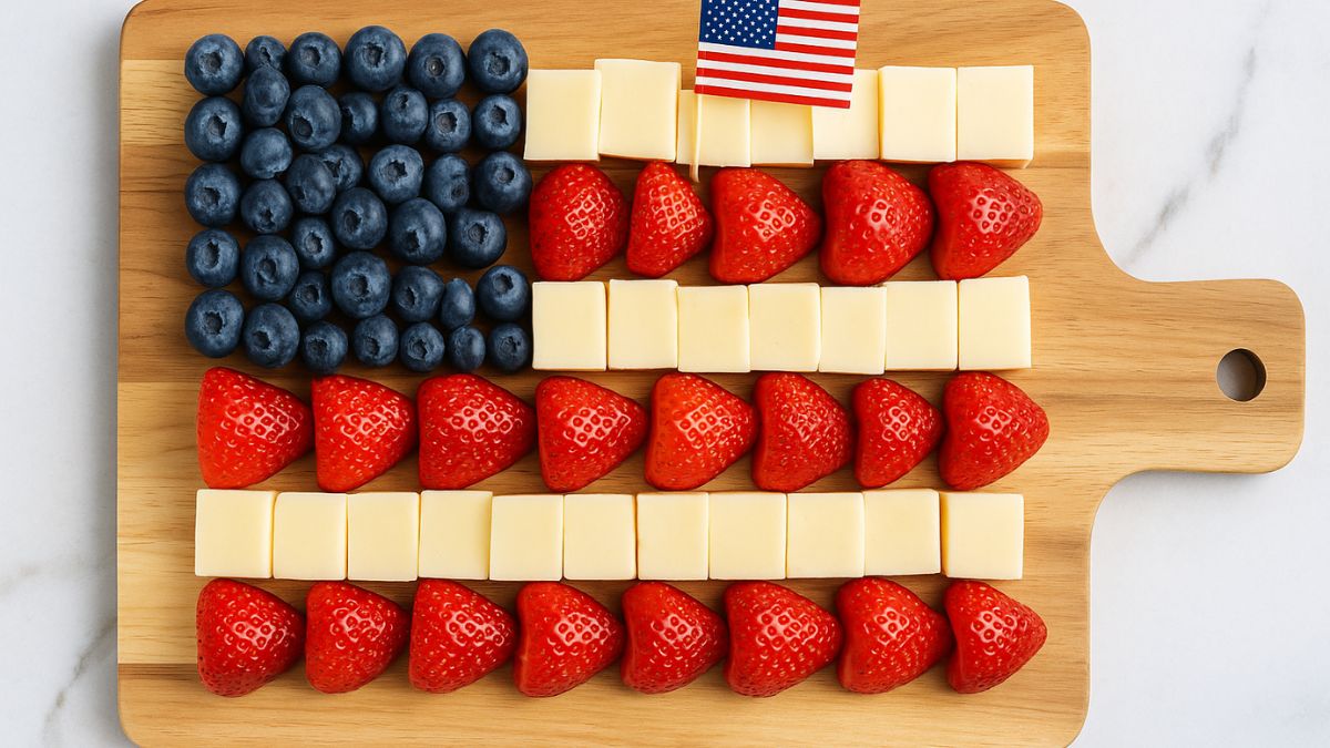American flag-themed charcuterie board with blueberries, cheese cubes, and strawberries