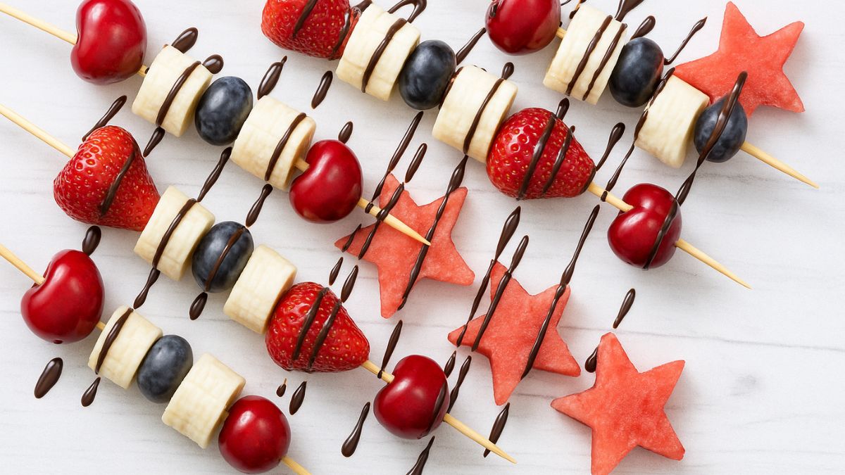 Healthy firecracker fruit skewers with bananas, berries, and chocolate drizzle