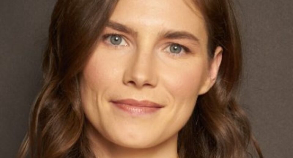 Close-up portrait of Amanda Knox with soft waves and a calm expression