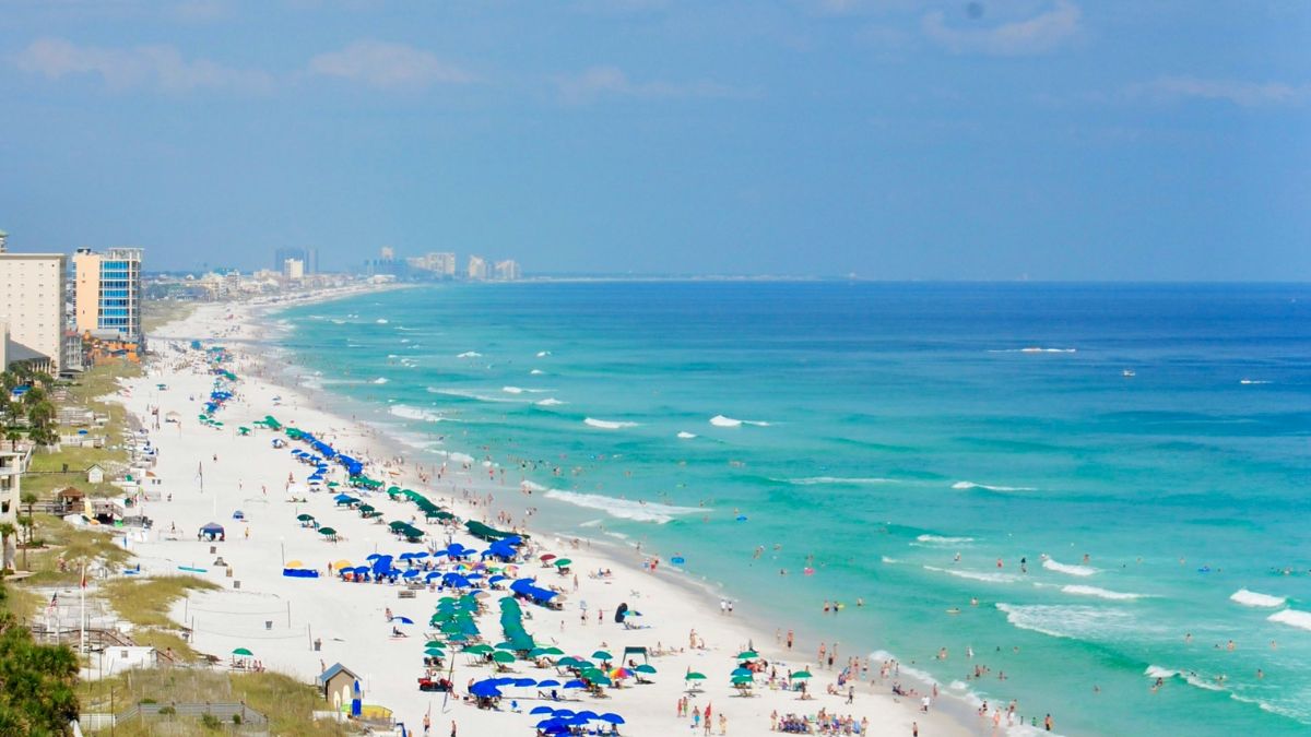 Aerial view of Destin Beach, Florida with rows of colorful umbrellas and turquoise waters