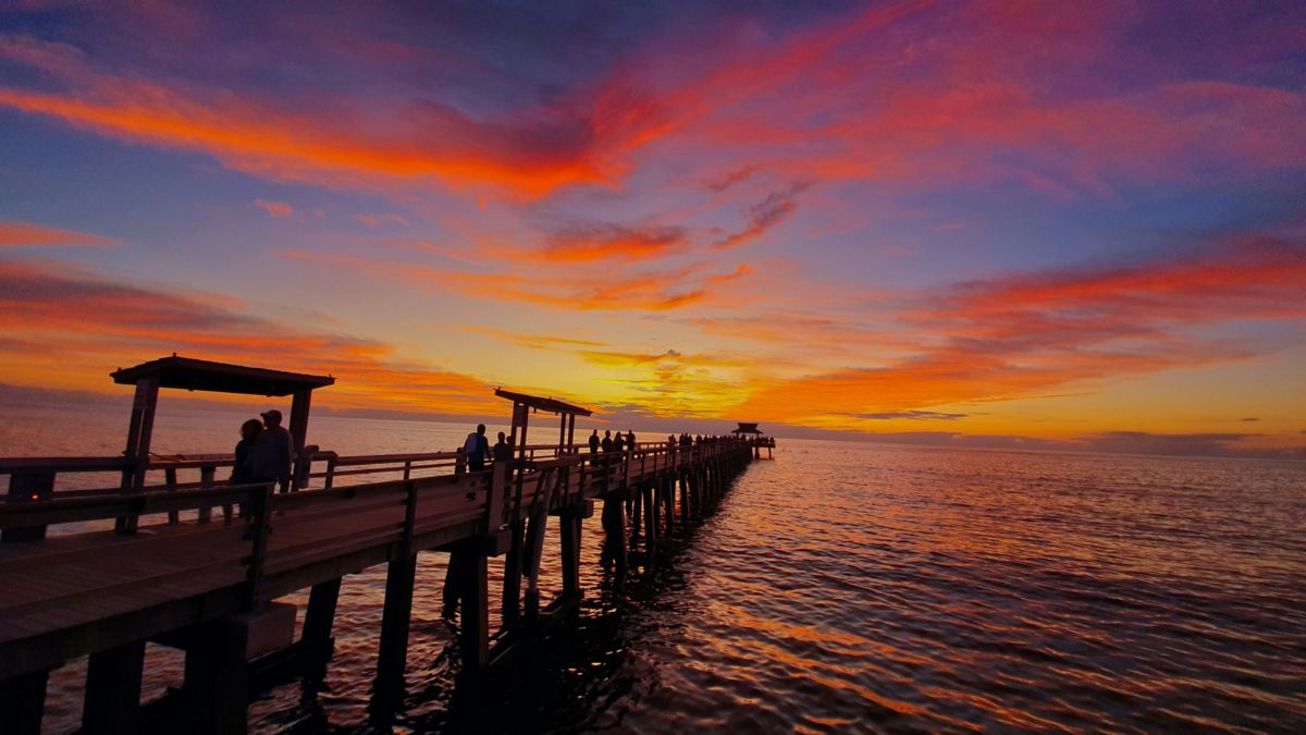 Sunset over Naples Pier in Florida with vibrant orange and pink skies