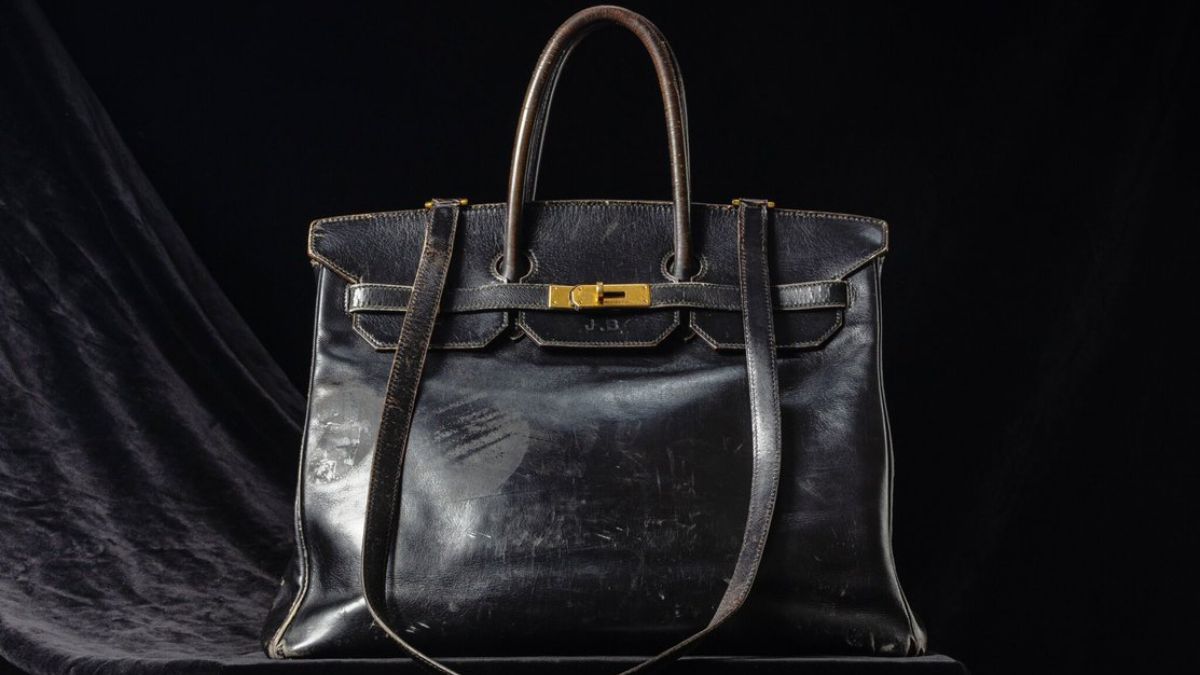 Jane Birkin’s original black Hermès Birkin bag displayed on dark velvet backdrop
