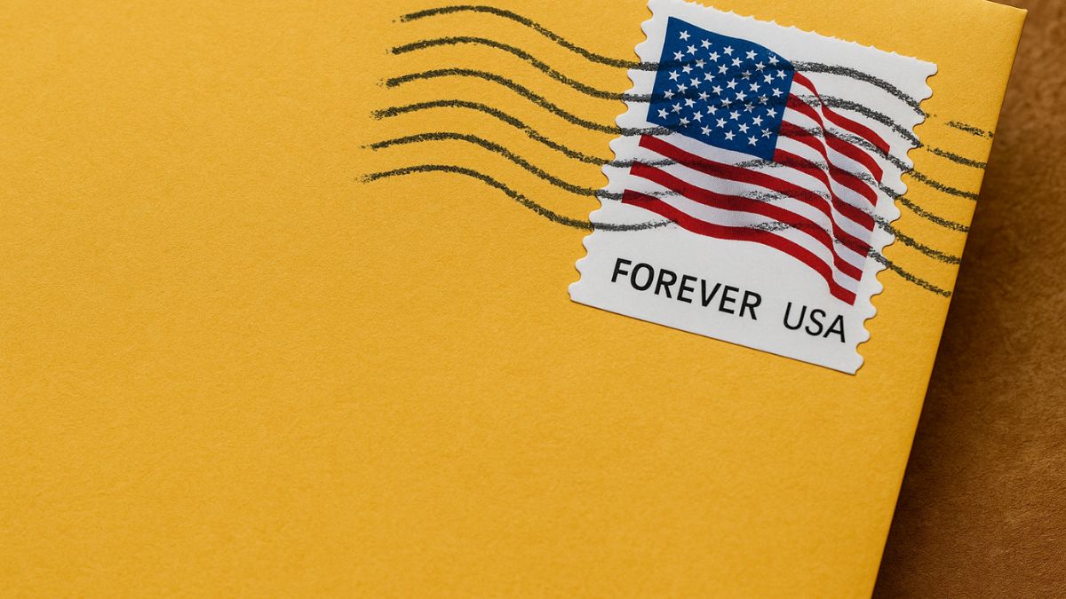 Close-up of a USPS Forever stamp on a yellow envelope with postmark